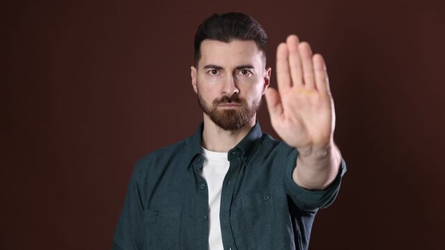 Man showing stop sign on brown background
