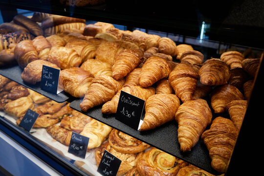 These images showcase casual dining in Paris, featuring a messy fried chicken burger, a classic McDonald's cheeseburger with fries, and a bakery display full of fresh, golden croissants with Euro pric