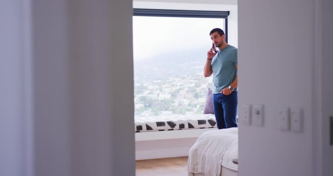 Door opening revealing male in his 30s walking to window seat while talking on smartphone