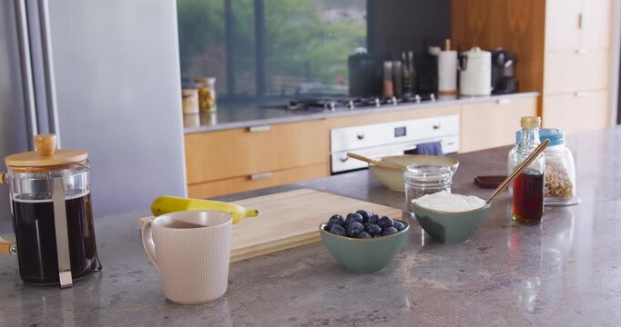 Camera starting slow sliding across stone counter, reframing French press, bowls for breakfast prep