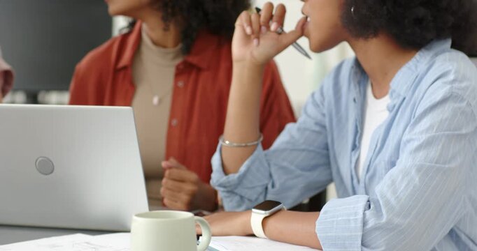 African American women in office holding pen, listening to speaker entering, explaining with laptop
