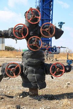 Close-up of a multi-valve wellhead assembly at an oil field