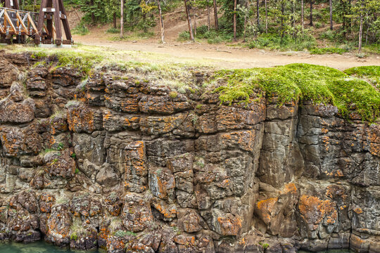 The rock stack that has stood the test of time and creates the teal blue waters of Yukon river. Yukon river flows through the Miles Canyon. Whitehorse, YT, Canada