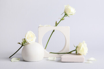 Naklejka premium Decorative podiums with beautiful white rose flowers on grey background