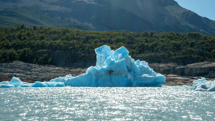 Floating blue icebergs in cold glacial water, natural polar landscape with frozen ice formations and calm surface © Daryna
