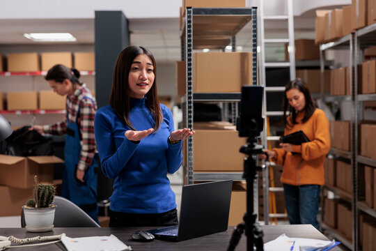 Postal service warehouse worker recording explainer video on mobile phone about parcel dispatching management. Post office storehouse manager streaming delivery manager working in storage
