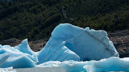 Floating blue icebergs in cold glacial water, natural polar landscape with frozen ice formations and calm surface © Daryna
