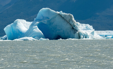 Floating blue icebergs in cold glacial water, natural polar landscape with frozen ice formations and calm surface © Daryna