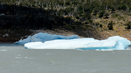 Floating blue icebergs in cold glacial water, natural polar landscape with frozen ice formations and calm surface © Daryna