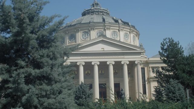 Tilt up shot of the athenium in Bucharest with vegetation in the foreground