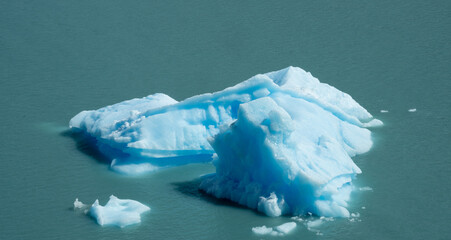 Floating blue icebergs in cold glacial water, natural polar landscape with frozen ice formations and calm surface © Daryna
