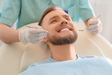 Obraz na płótnie Canvas Young man visiting dentist on couch in clinic, closeup