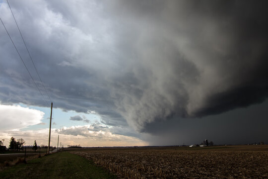 A thick shelf cloud looms in the sky as a storm approaches.