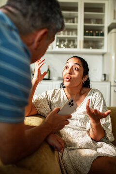 Couple arguing at home over smartphone