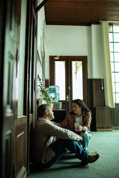 Two coworkers comforting each other in office hallway