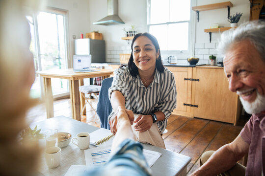Financial advisor shakes hands with senior clients at home