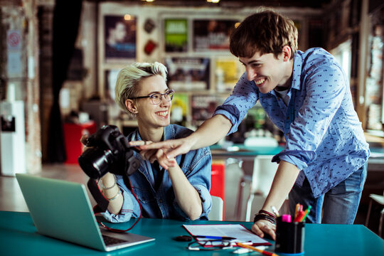 Two creative coworkers reviewing photos on camera in a studio