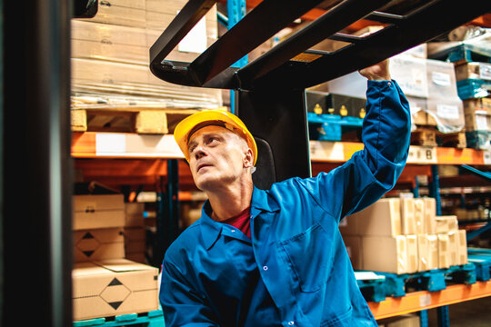 Warehouse worker operating forklift in distribution center