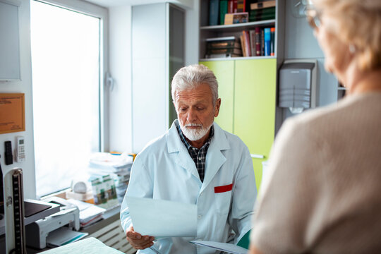 Senior doctor reviewing test results with patient in clinic
