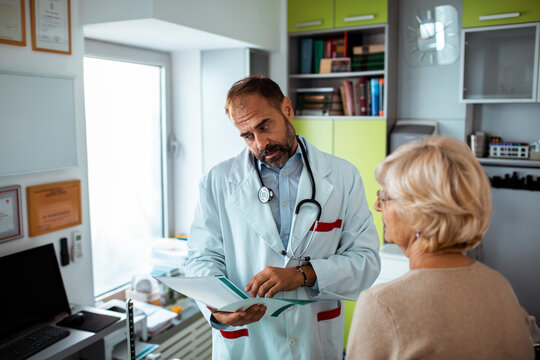 Male doctor discussing test results with senior female patient in medical clinic