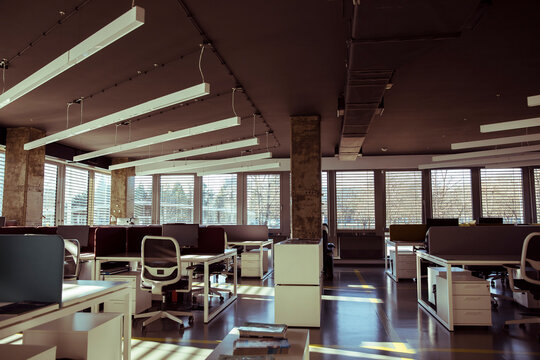 Empty open-plan office workspace with natural light in modern coworking studio