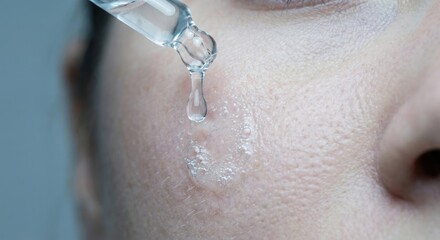 Fototapeta premium Exfoliating acid serum dripping onto human skin with bubbles