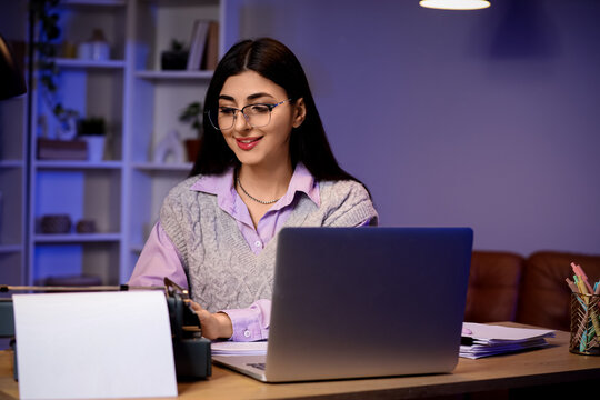 Female screenwriter using vintage typewriter in office at night