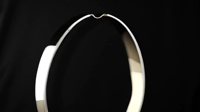 Silver Jewelry Bangles Rotating on Black Background.