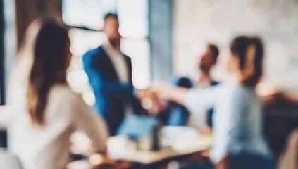 Fototapeta premium Blurred image showing four people in a business meeting or discussion in a modern office setting.
