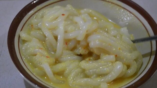 Close-up of Lakso (Laksa) from Bangka Belitung, Indonesia, a traditional noodle dish served in rich coconut milk broth. Featuring thick white noodles with savory and creamy texture, popular in Indones