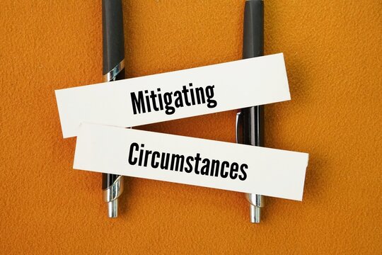 Pen and paper with the words Mitigating Circumstances. factors or events that reduce the severity, culpability, or impact of a negative action