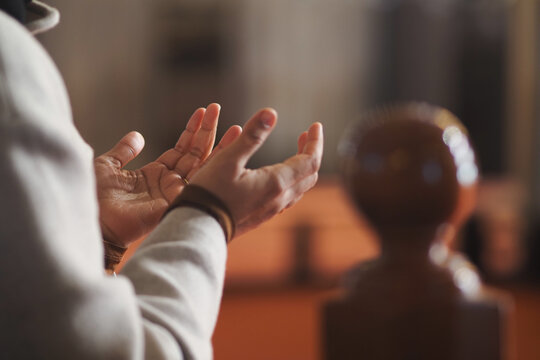 muslim woman hands raised in prayer inside a mosque