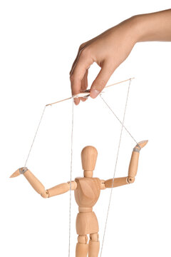 Hand of puppeteer manipulating marionette on white background
