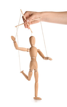 Hand of puppeteer manipulating marionette on white background