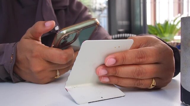 Using a phone while holding QR code to scan the cafe menu