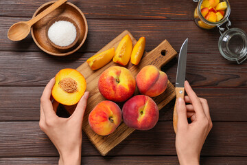 Woman preparing sweet peach jam on wooden background
