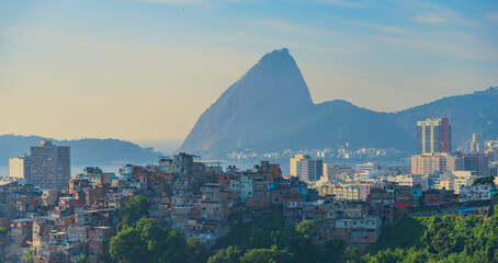  Iconic Sugarloaf Mountain rising above Rio de Janeiro favelas and urban skyline with copy space