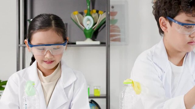 Asian Elementary Students in Lab Coats Conducting Science Experiment with Balloons
