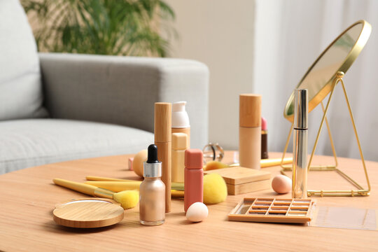 Decorative cosmetics, makeup accessories and mirror on wooden table in room