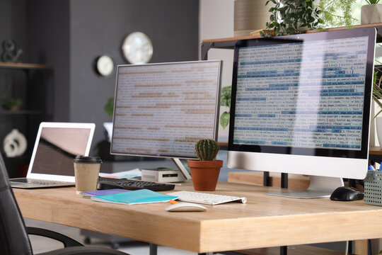Programmer's workplace with computer monitors in office