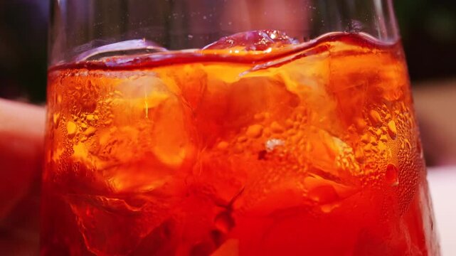 Detailed macro of a refreshing cocktail with ice cubes and water droplets on glass surface