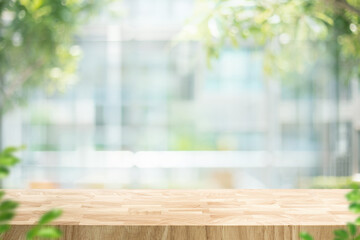 Selective focus.Wood table counter on blur big glass wall with green nature
