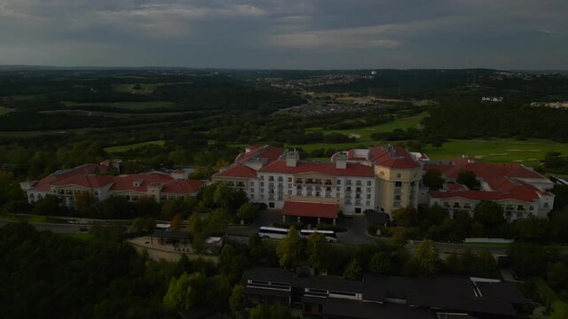 Aerial drone footage of a large resort surrounded by green hills in san antonio, texas. Ideal for tourism or real estate promotion. 11.4s duration, 3840x2160 resolution. Shot in 60fps for smooth sl...