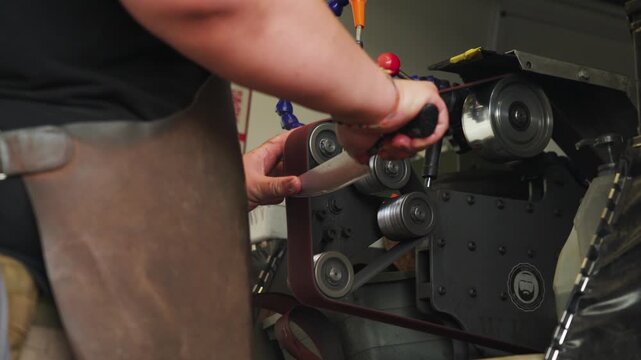 Knife sharpening machine in operation in Malaysia. Close-up of belt system and mechanical components refining blade edges, highlighting industrial process and precision engineering.