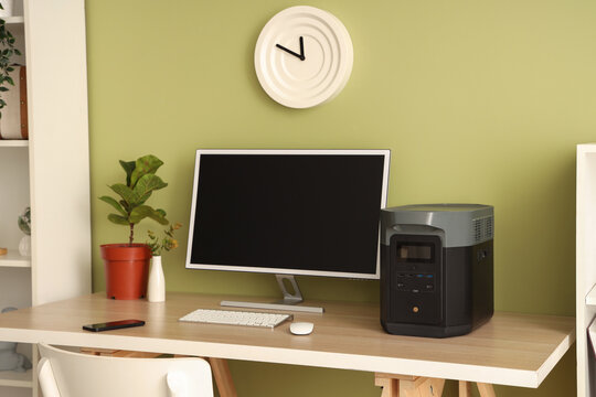 Workplace with computer and portable power station in office