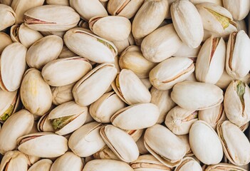 Fototapeta premium Pistachio background. Close-Up View of Raw Pistachio Nuts Piled Together in a Natural Setting