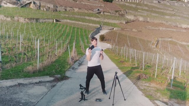 Photographer with cameras, tripod, gimbal, drone in Lavaux during the day in Canton of Vaud, Switzerland, static shot