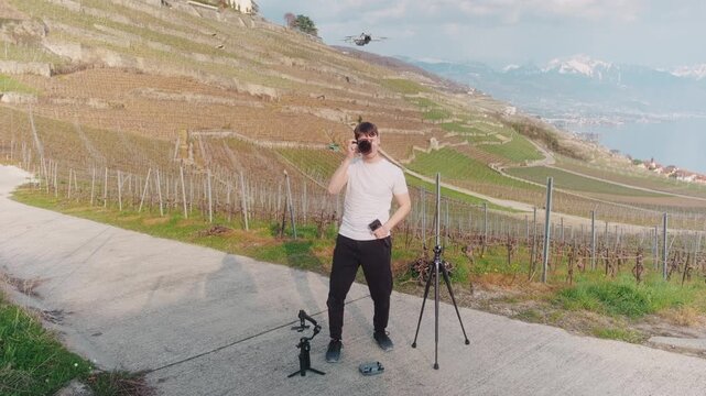Photographer with cameras, tripod, gimbal, drone in Lavaux with Lake Geneva during the day in Canton of Vaud, Switzerland, static shot