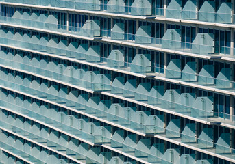 This image showcases a striking modern building with unique glass balconies, emphasizing its architectural elegance and contemporary style in urban settings. © Veronique