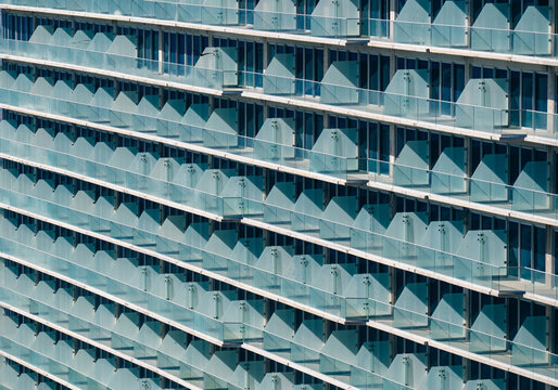This image showcases a striking modern building with unique glass balconies, emphasizing its architectural elegance and contemporary style in urban settings.